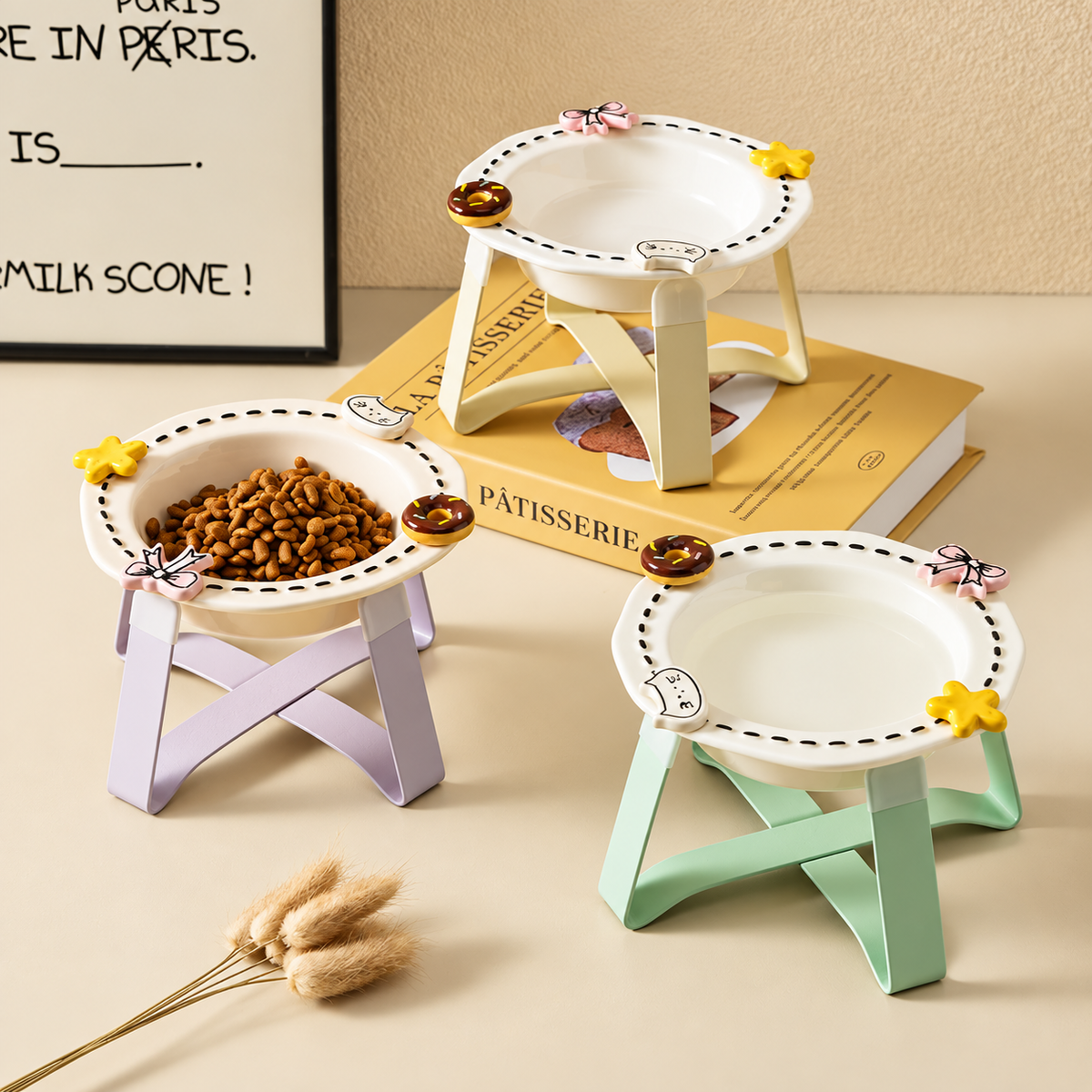 Three decorative raised ceramic cat bowls displayed with pastel stands